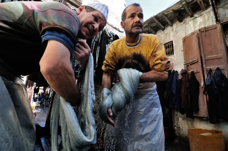 FES - MARCH 10: Two unknown people works to wash thread in a Market (souk) in a city Fes in Morocco. The market is one of the most important attractions of the city. March 10, 2012 Fes, Morocco.のeditorial素材