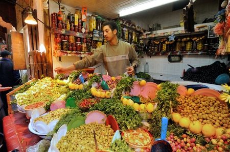 FES - MARCH 10: Unknown man trades a green olives in a Market (souk) in a city Fes in Morocco. The market is one of the most important attractions of the city. March 10, 2012 Fes, Morocco.のeditorial素材