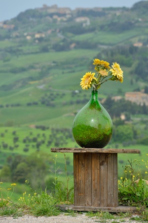 Glass bottle with flowers and landscape - Italy, Tuscanyの写真素材