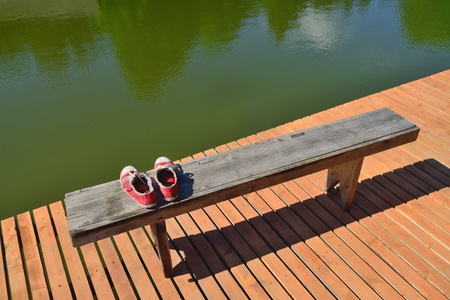 Old red shoes on a benchの写真素材