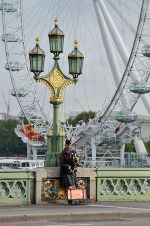 LONDON - OCTOBER 04: unidentified bagpiper on the Westminster Bridge on October 04, 2014 in London, UK. London is one of the worldのeditorial素材