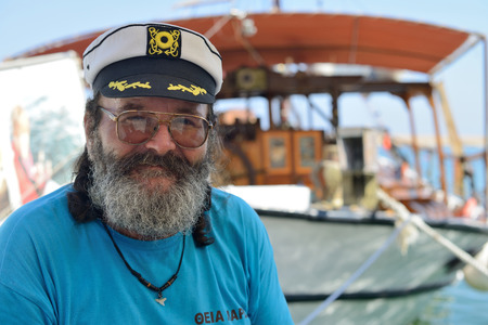 CHANIA, GREECE - AUGUST 12: Unknown man, captain of cruise boat in Chania harbor, Greece on August 12, 2014. Chania is one of the most popular tourist place on Crete island in Greece.のeditorial素材