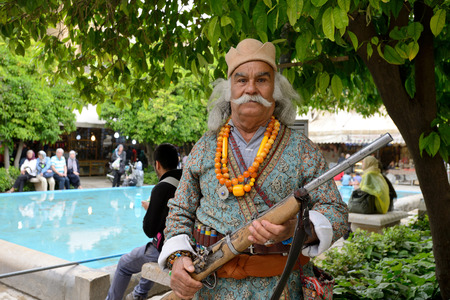 SHIRAZ  APRIL 15: Unknown man with rifle posing in market Vakil Bazaar in Shiraz Iran on April 15 2015. Vakil Bazaar is the most important tourist attraction in Shiraz Iran.のeditorial素材