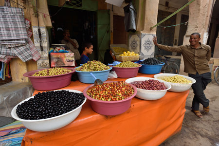 RISSANI - AUGUST 03: Unknown man trades a olives in a Market souk in a Rissani in Morocco. The market is one of the most important attractions of the city. August 03, 2012 Rissani, Morocco.のeditorial素材