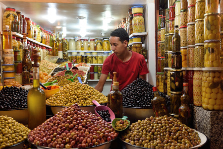 MARRAKESH - AUGUST 07: Unknown man trades a green olives in a market (souk), August 07, 2015 in a Marrakesh, Morocco. The market is one of the most important attractions of the city Marrakesh, Moroccoのeditorial素材