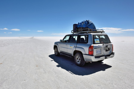 SALAR DE UYUNI - AUGUST 28: Off-road car on surface of lake Salar de Uyuni in Bolivia on August 28, 2016. Salar de Uyuni is the worlds largest salt flat at 10,582 square kilometersのeditorial素材
