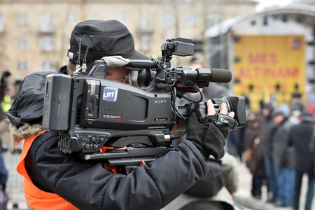 Vilnius, Lithuania - April 15, 2018: TV camera man filming a political event in Vilnius on April 15, 2018. Vilnius is the capital of Lithuania and its largest cityのeditorial素材