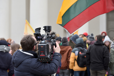 Vilnius, Lithuania - February 16: TV camera man filming a political event in Vilnius on February 16, 2019. Vilnius is the capital of Lithuania and its largest cityのeditorial素材