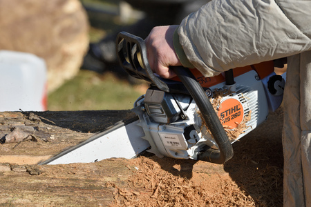 Kaunas, Lithuania - April 04: Unidentified man cutting wood with Stihl chainsaw in Kaunas on April 04, 2019. Stihl is a German manufacturer of chainsaws and other handheld power equipmentのeditorial素材