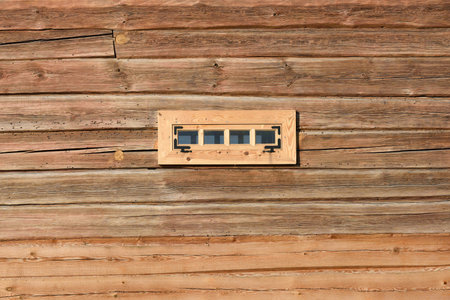 Wall of log house with small window, Wood Background. Country style