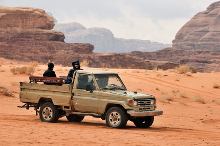 Wadi Rum Village, Jordan - February 19, 2020. Tourists sitting in pickup truck and enjoying a guided...
