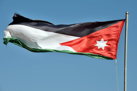 The flag of Jordan blowing in the wind in Petra, Jordan.