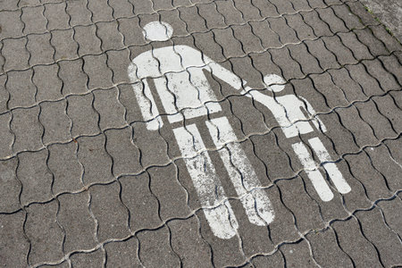 White road markings on pavement. Signs of pedestrian aon the road