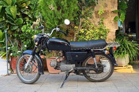 Black vintage motorcycle motorbike standing at the old town street, Greeceの写真素材