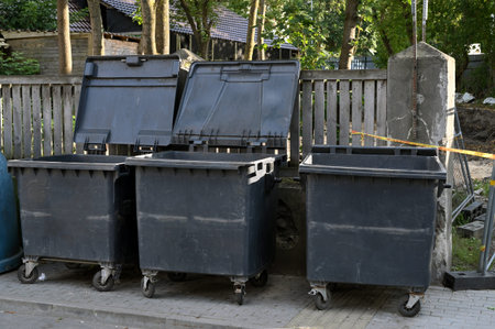 Large garbage containers, trash dumpsters standing in row in city streetの写真素材