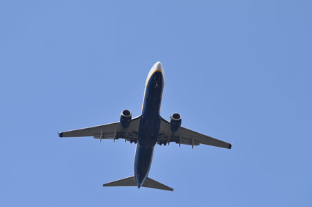 Passenger airplane flying on blue sky and spread the wheels prepare to landinの写真素材