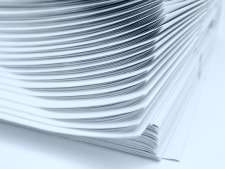 heap of newspapers isolated. blue tinted. focus on upper part
