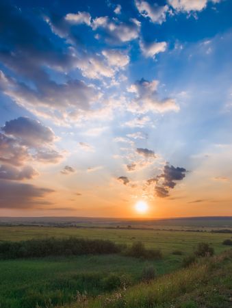 sunset over green meadow landscape. verticalの写真素材