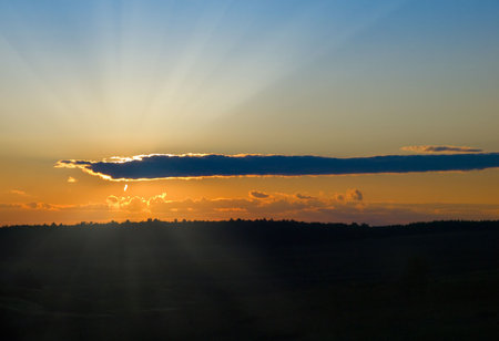 sunset with dark cloud over meadow landscape