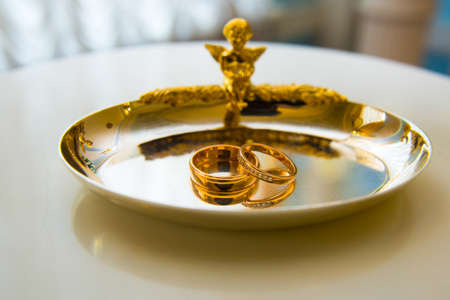 Beautiful gold jewelry lying around flowersの写真素材