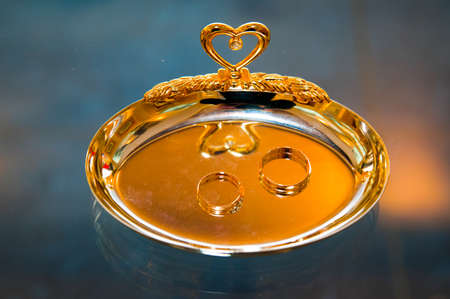 Beautiful gold jewelry lying around flowersの写真素材