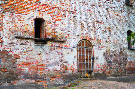 Ancient medieval building with exposed stone walls and a towerの写真素材