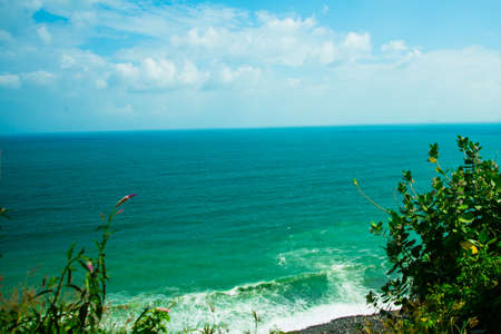 Sea view panorama. Small rocks near the shore, waves and white clouds on a blue sky.Vietnam