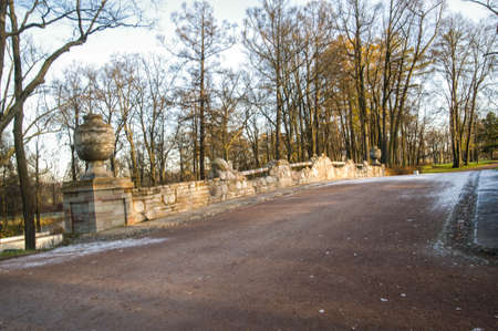The bridge over the river made of stone and decorated vases.Ruin the bridge in the Park of Alexandria. Russia.Saint-Petersburg.Peterhof.の写真素材