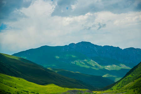 The peaks of blue-green mountains against the sky,the summer.The Caucasus..Russia.