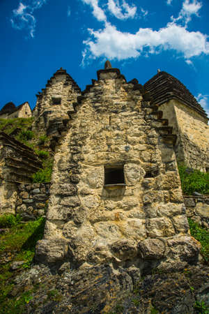 City of the dead.Stone ancestral tombs on the hill with mountains in the background, inside the bone. The Caucasus.Russia.の写真素材