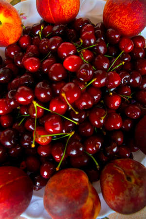 Cherry and peach on the plateの写真素材