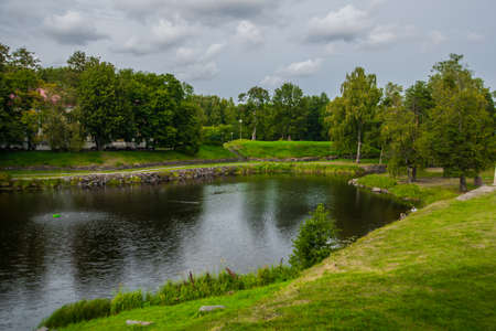 Beautiful lake and trees reflected water.Summer,sky with clouds, cloudy weather.Russia,the city of Priozersk.の写真素材