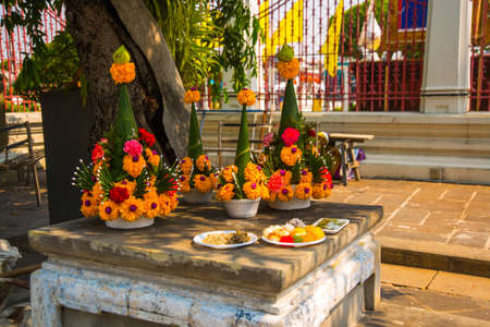 Orange flowers and offerings to Buddha at the temple on the table of the Buddha. Thailand. Bangkok.の写真素材