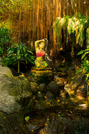 A small statue on the background of water and rocks at the temple. Thailand. Bangkok.の写真素材