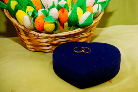 Two gold wedding rings lie on a bouquet.の写真素材