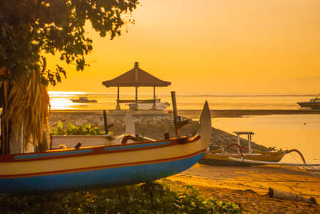 Traditional Balinese ships Jukung in Sanur beach at sunrise, Bali, Indonesiaの写真素材