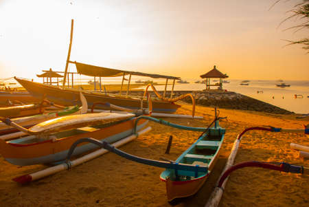 Traditional Balinese ships Jukung in Sanur beach at sunrise, Bali, Indonesiaの写真素材