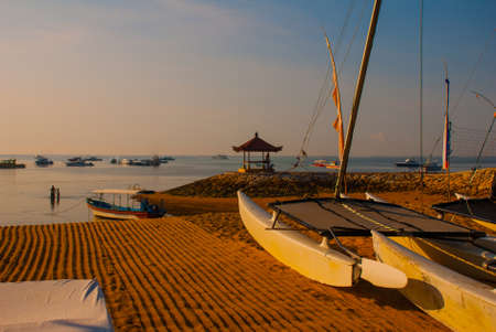 Traditional Balinese ships Jukung in Sanur beach at sunrise, Bali, Indonesiaの写真素材