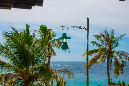 Apo island,Philippines, view on island beach line. Palm trees, lantern, sea and boats. The tropical landscape, view from the top.の写真素材