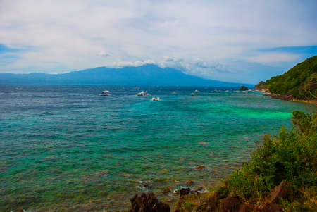 Apo island,Philippines, view on island beach line: mountain, sea and boats, the view from the top.の写真素材
