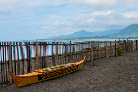 The boat and the fence on the beach on sea background. Pandan, Panay island, Philippines.の写真素材