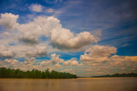 Landscape with yellow river and blue sky with clouds. Sarawak, Malaysia, Borneoの写真素材