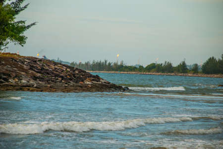 Landscape view of the water in the evening pipe with the fire on the horizon, city Bintulu, Borneo,...