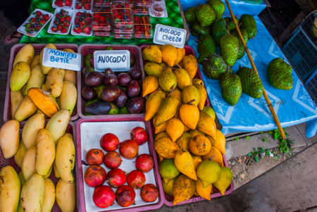 The traditional Asian market with food. Sale a variety of fruits lying on the counter Malaysiaの写真素材