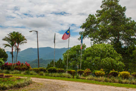 The landscape on the island of Borneo. Flag of Malaysia on the background of nature Sabah, Malaysia.
