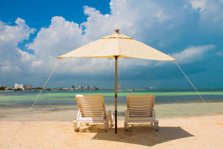 Sun umbrella and beach beds on tropical sandy beach, Tropical destinations. Cancun, Mexico. Mexicoの写真素材