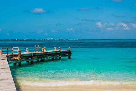 Beautiful outdoor view of a wooden pier, white sand beach of Caribbean sea in Cancun Mexicoの写真素材