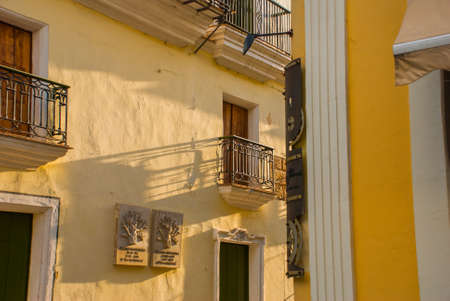 Fragment of a yellow house with the street name plate in downtown Havana. Cuba. Old Havana District.