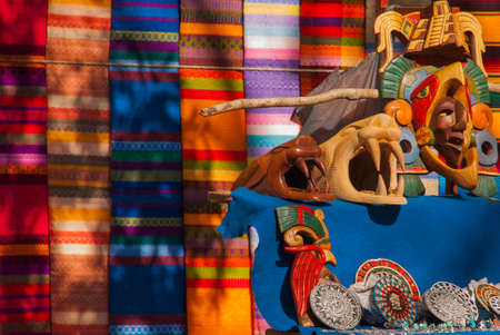 Souvenirs from Mexico in the market. Mexican Mayan crafts, embroidery on fabric, plates, pyramids....