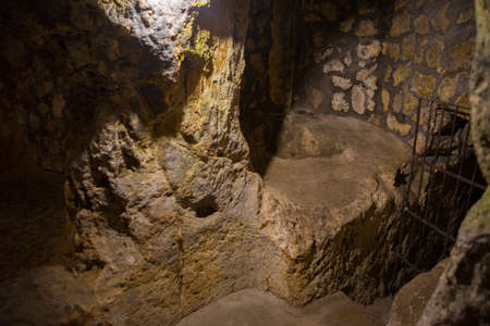 The Derinkuyu underground city is an ancient multi-level cave city in Cappadocia, Turkey. Stone used as a door in the old underground city. Green tourの写真素材